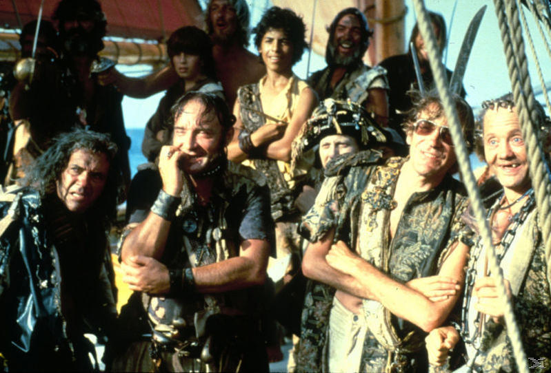 Eine Gruppe lächelnder Piraten an Bord eines Schiffes. Sie tragen verschiedene Outfits. Der Hintergrund zeigt das Meer und die Schiffsstruktur.