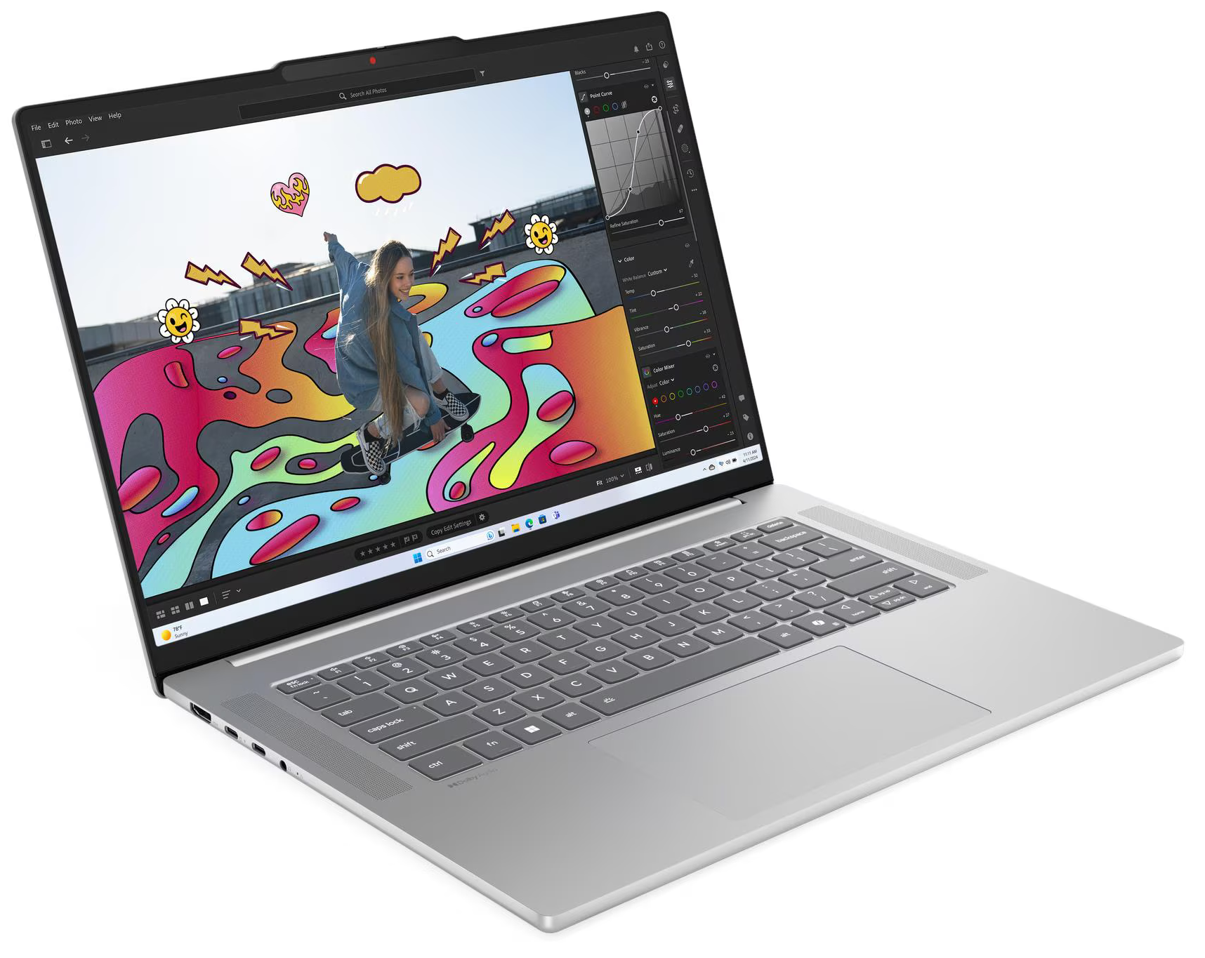 A laptop egy fotót jelenít meg egy gördeszkázó személyről színes művészettel. A laptop ezüstszínű, nyitott és szögben áll. A háttér fehér.