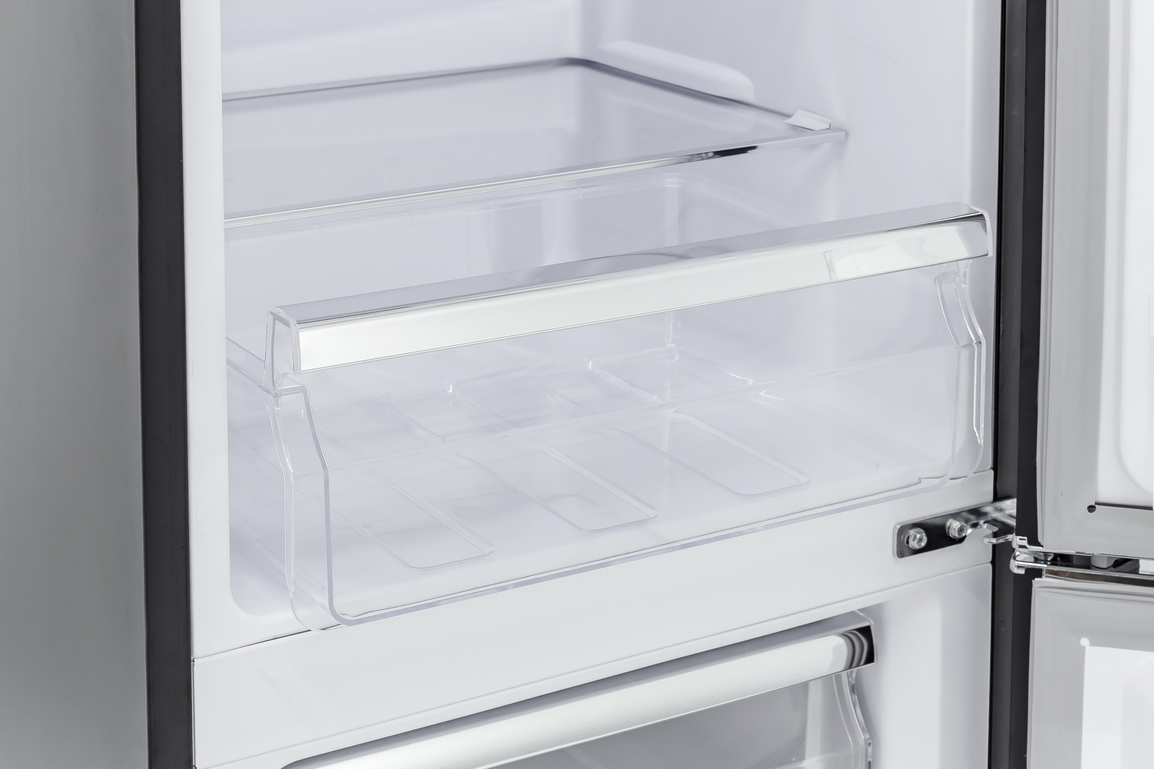 Ein offener Kühlschrank mit durchsichtigen Kunststoffschubladen und -regalen. Die Tür ist teilweise geöffnet.