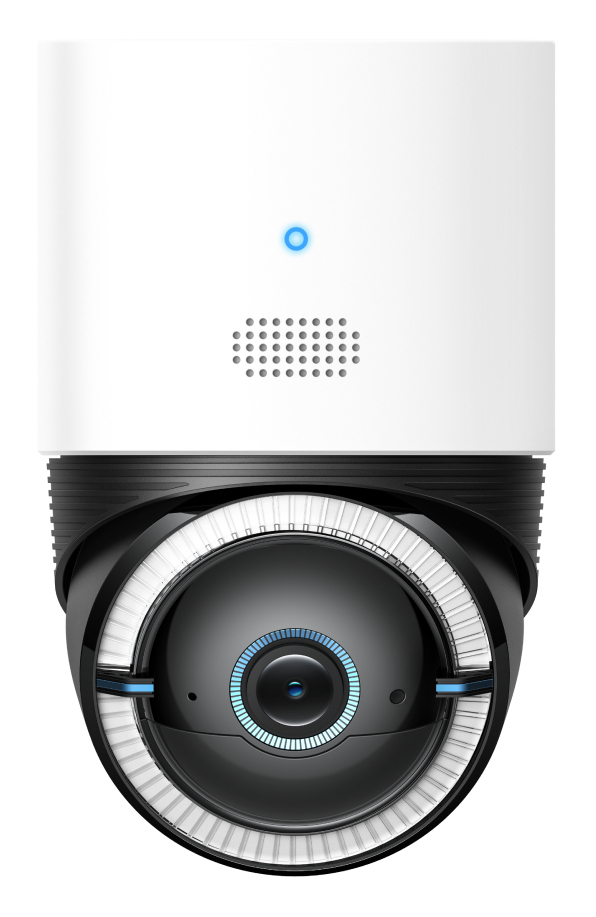Una cámara de seguridad con diseño en blanco y negro. Tiene lente circular y luz azul. La cámara está montada en una base blanca.