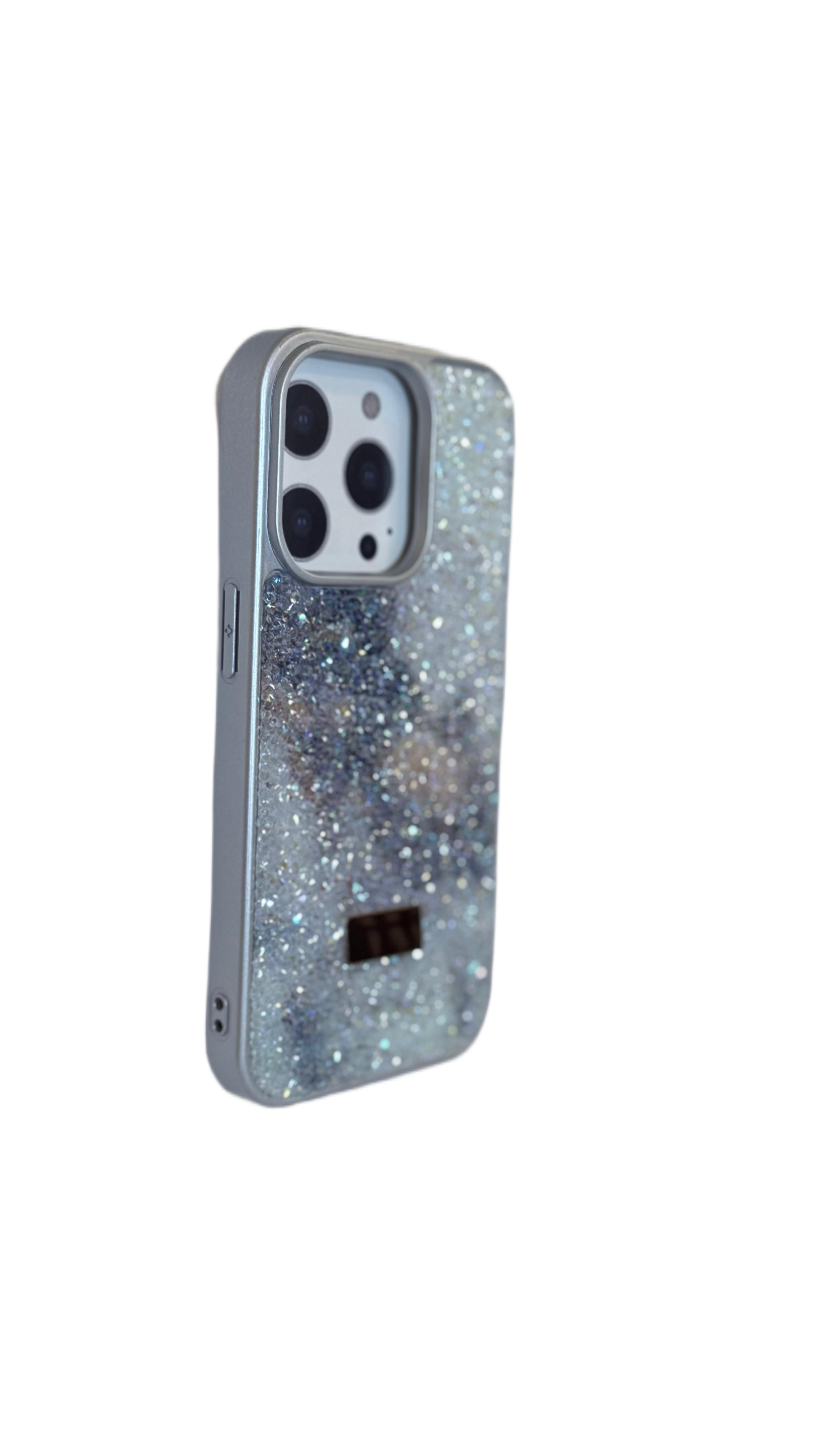 Parıldayan bir telefon kılıfı. Kılıf gümüş rengi, önünde parıltılar var. Siyah bir logoya sahip.