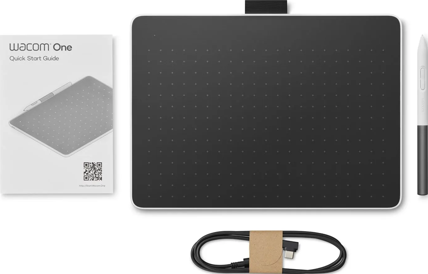 Tablette de dessin Wacom One avec stylet, guide de démarrage rapide et câble. La tablette est noire avec un bord blanc et a un stylet.
