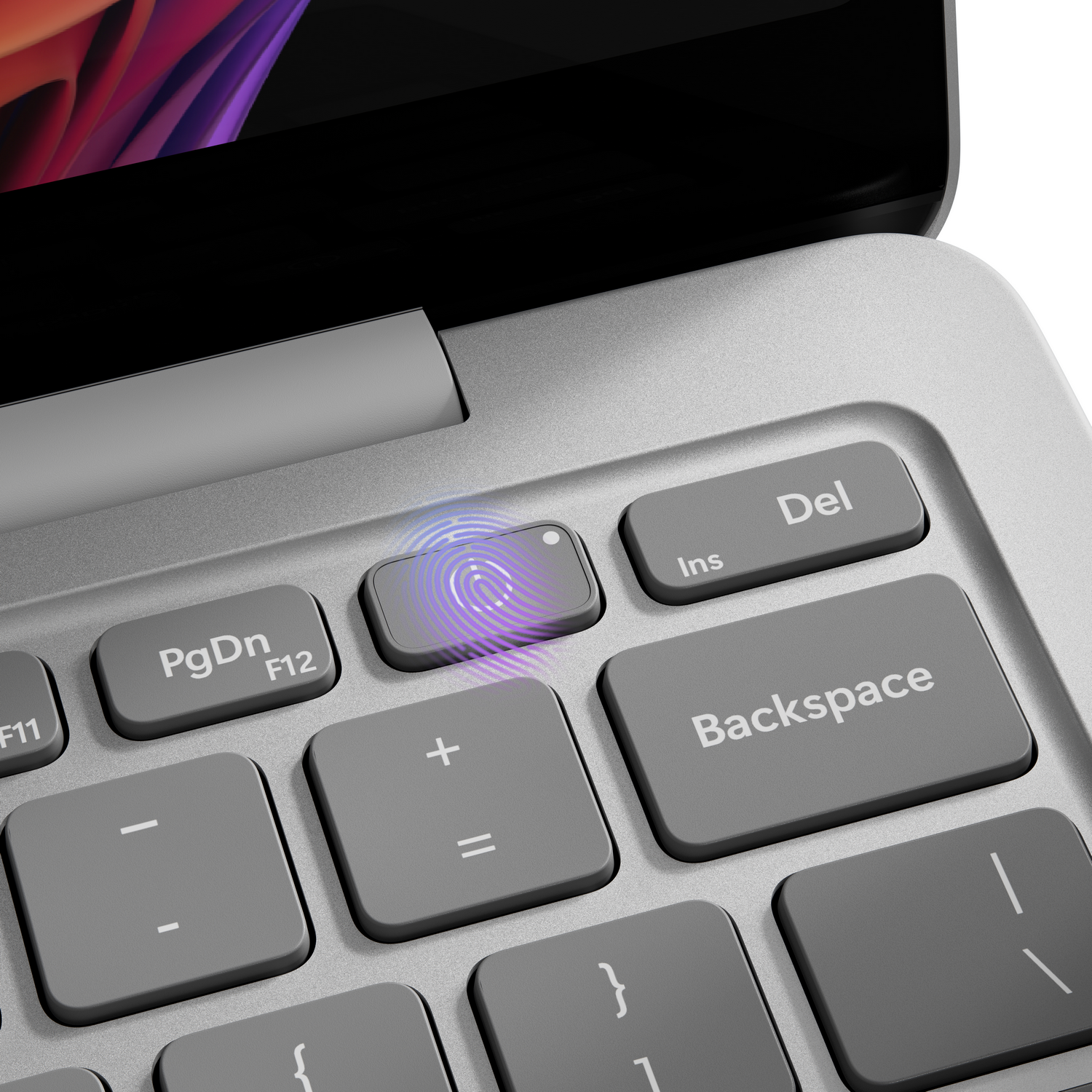 Primer plano de un teclado de portátil. El botón del escáner de huellas dactilares brilla. Las teclas incluyen Supr, Retroceso, AvPág y teclas de función.