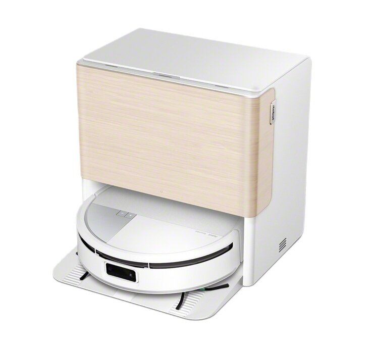 Biały i drewniany robot odkurzający zadokowany w stacji ładującej na białej powierzchni.