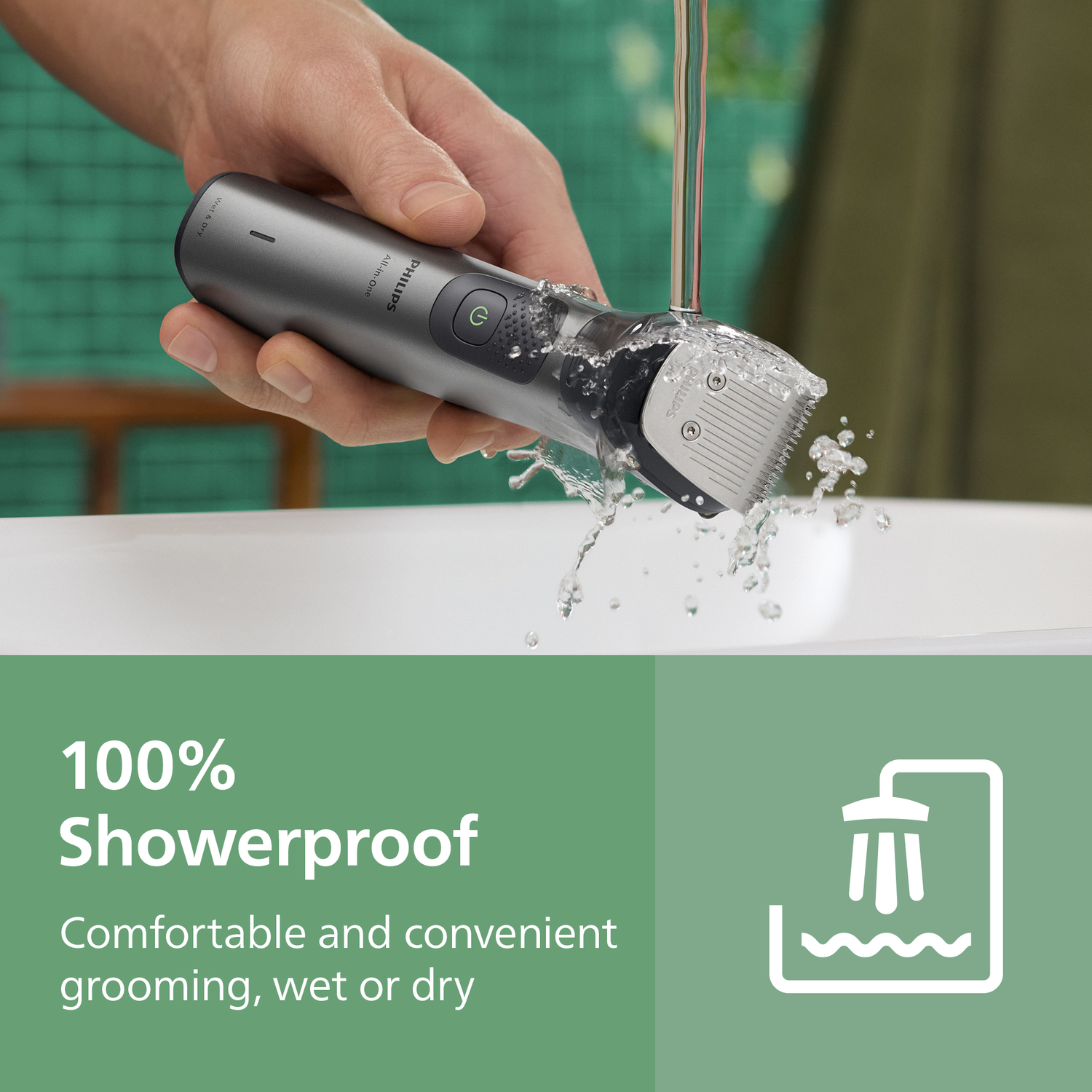 A hand holds a Philips All-in-One trimmer under running water. It's in a bathroom, with text saying '100% Showerproof'.