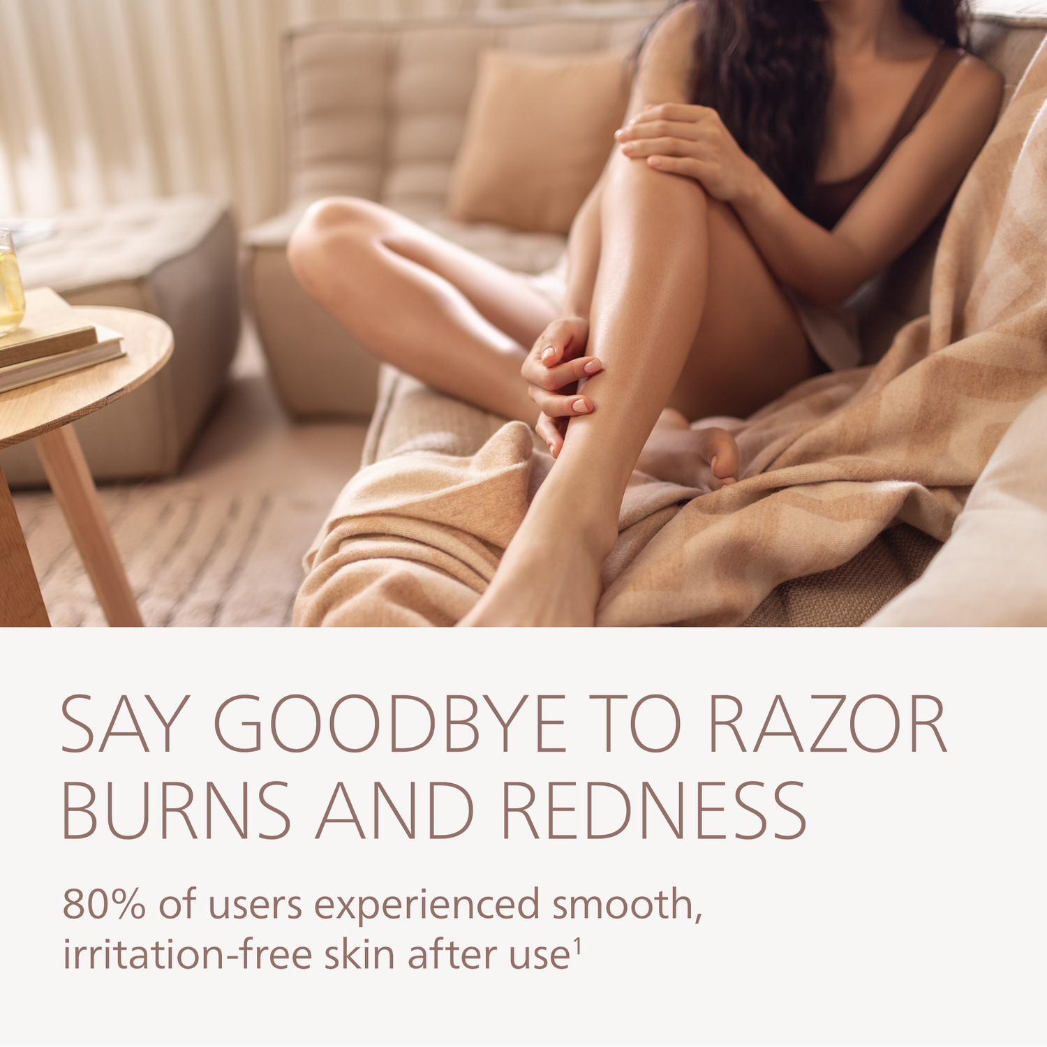 Woman sitting on a couch, touching her smooth leg. Text: Say goodbye to razor burns and redness. 80% experienced smooth skin.