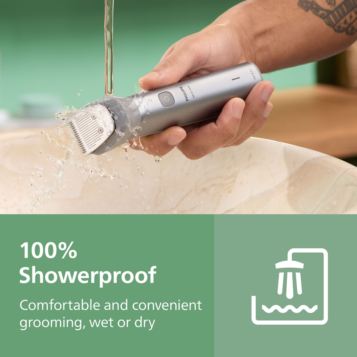 Een hand houdt een zilveren Philips-scheerapparaat vast, met opspattend water. Op de achtergrond een waterdichte tekst en pictogram.