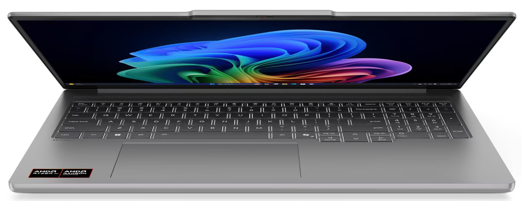 Egy ezüst laptop nyitva, színes absztrakt képet jelenít meg. A billentyűzet látható. AMD Ryzen és Radeon matricák találhatók.