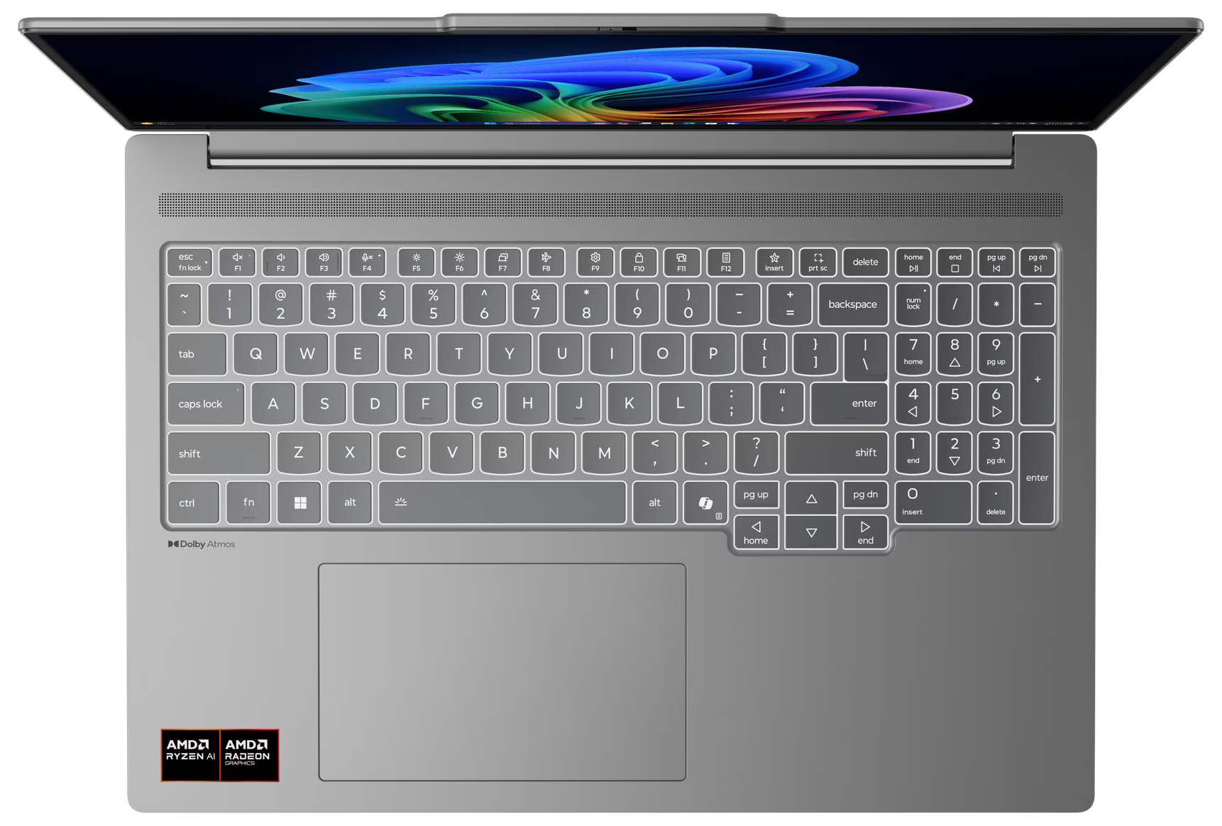 Laptop felülnézetből, billentyűzet látható. Fehér gombok fekete betűkkel. Képernyőn színes absztrakt minta. Szürke tok.