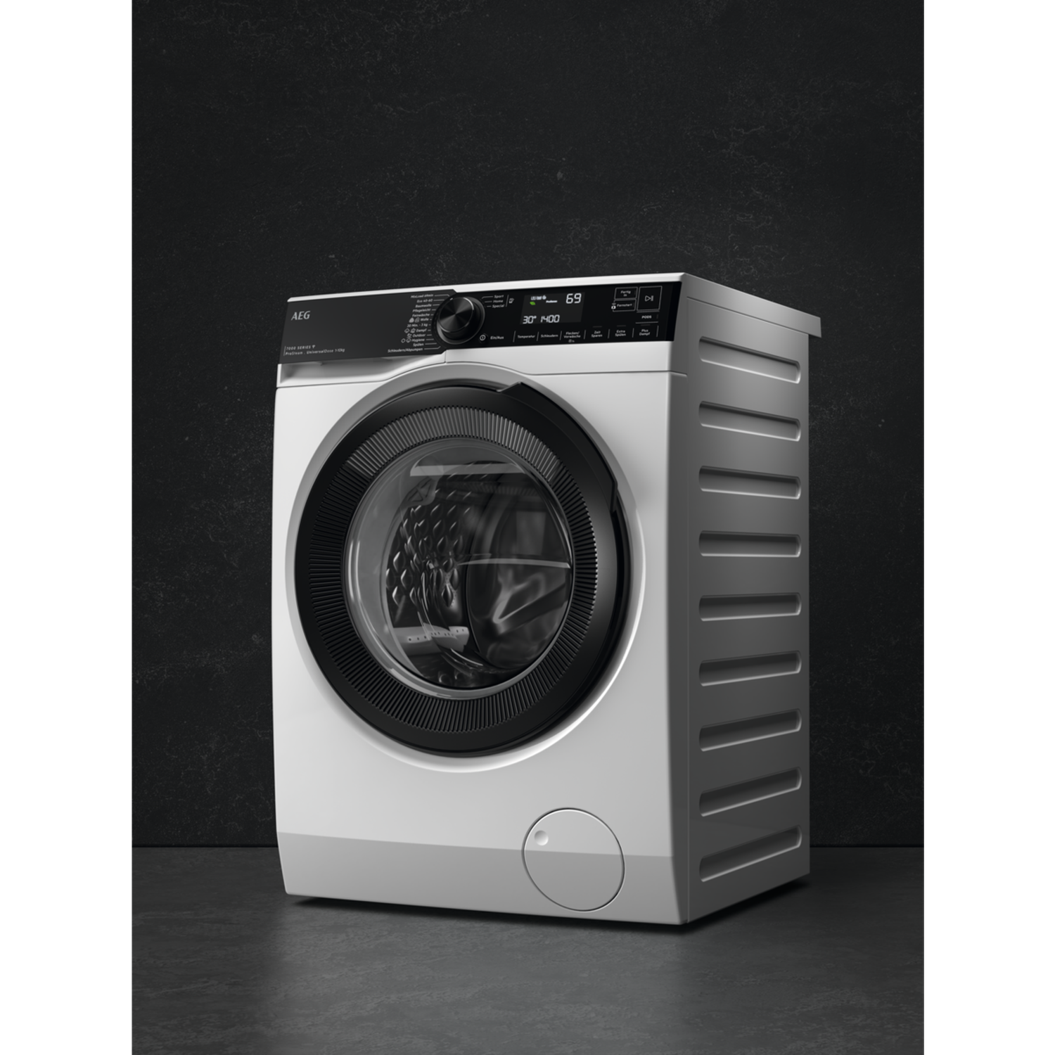 A white AEG washing machine with a black door. The display shows 30 degrees and 1400. It stands on a gray surface against a dark wall.