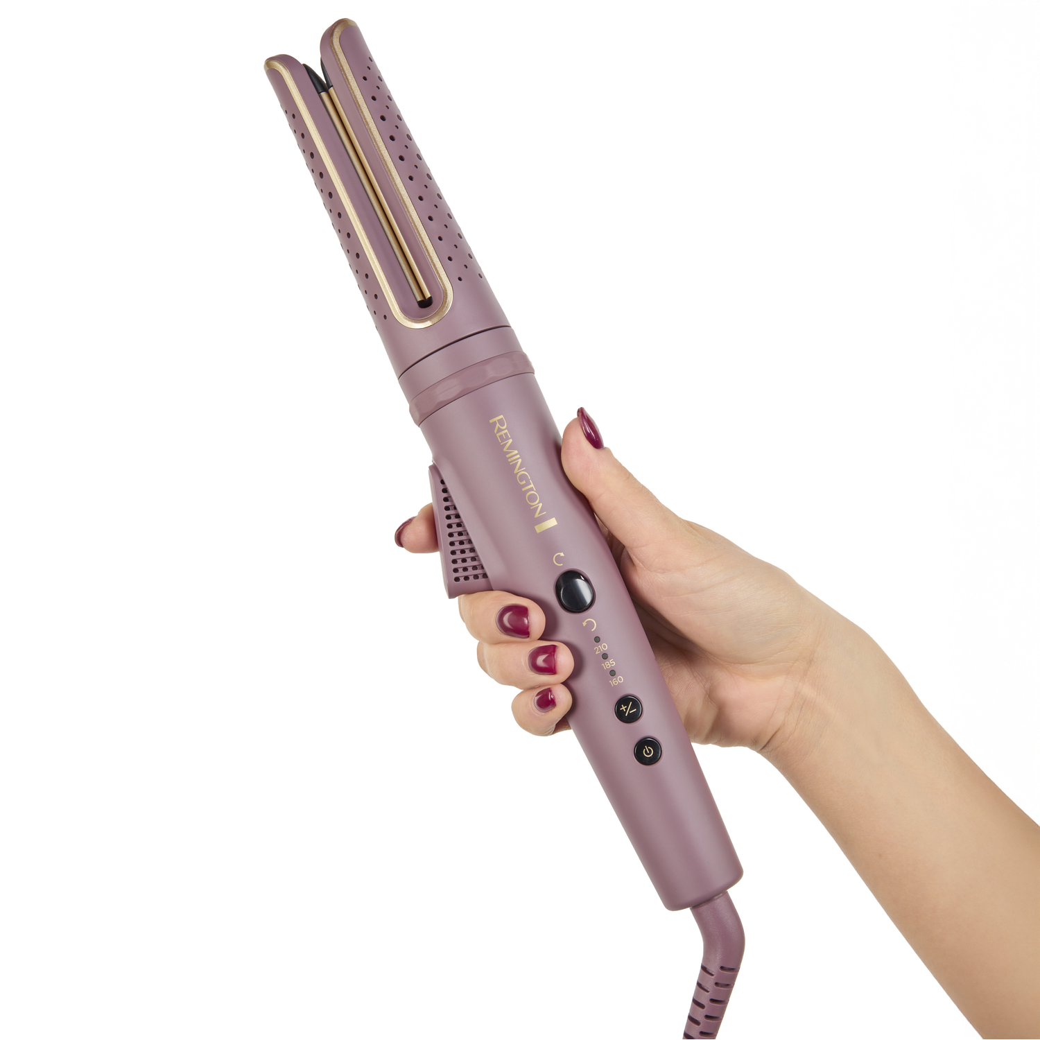 A woman's hand holds a purple Remington hair curler. The curler has gold accents and buttons. The woman has red nail polish.