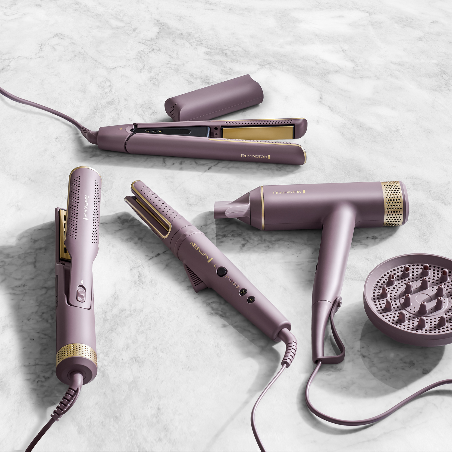 Een bovenaanzicht van haarstylingtools. Bevat een stijltang, krultang, föhn en diffuser. Allemaal lavendel en goud.