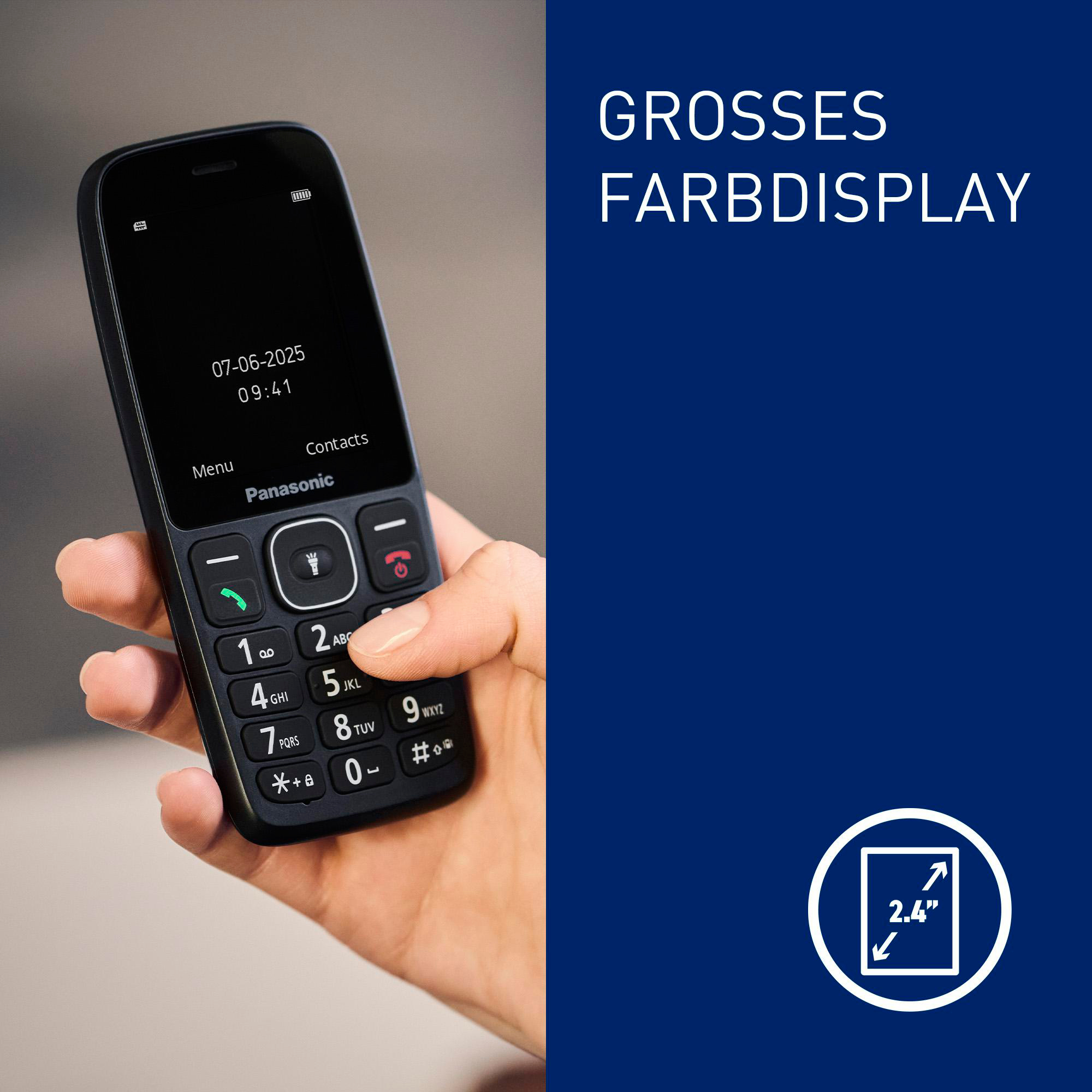 Eine Hand hält ein Panasonic-Mobiltelefon. Der Bildschirm zeigt Datum und Uhrzeit an. Der Hintergrund ist dunkelblau.