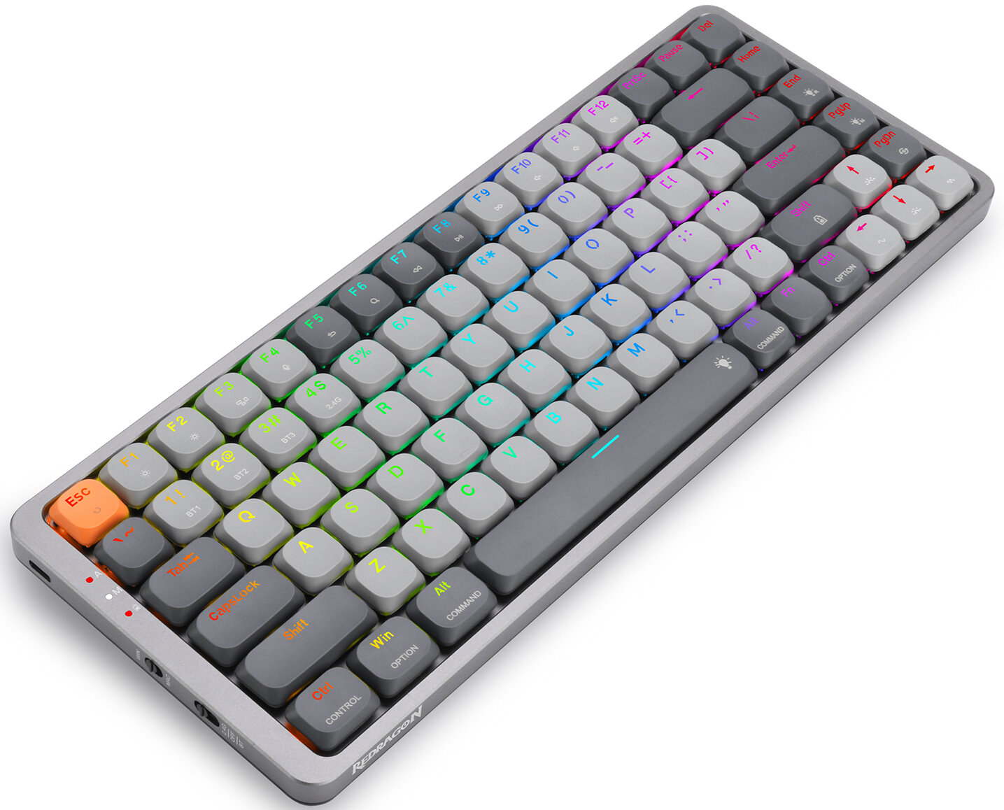 Kompaktowa, srebrna klawiatura Redragon z szarymi i kolorowymi klawiszami. Klawisze wyświetlają litery, cyfry i symbole. Klawiatura jest pochylona.