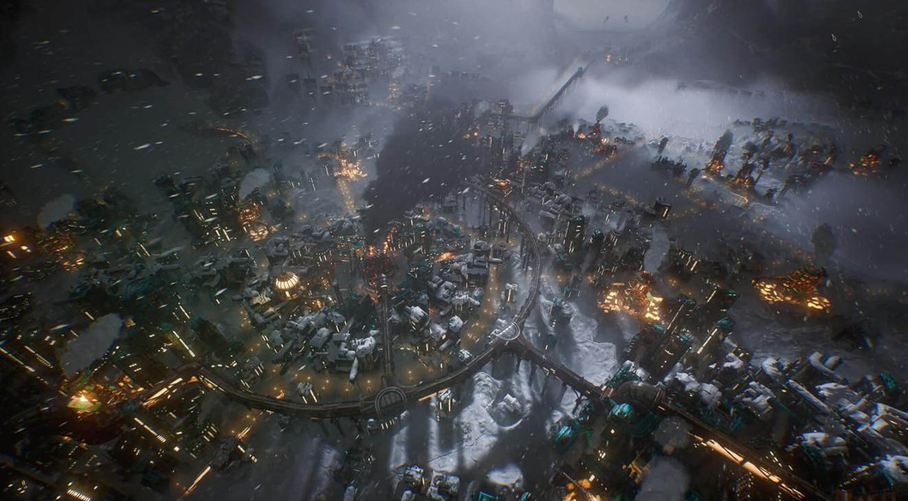 Eine Luftaufnahme einer futuristischen, schneebedeckten Stadt. Gebäude mit Lichtern verteilen sich über die Landschaft. Berge sind im Hintergrund.