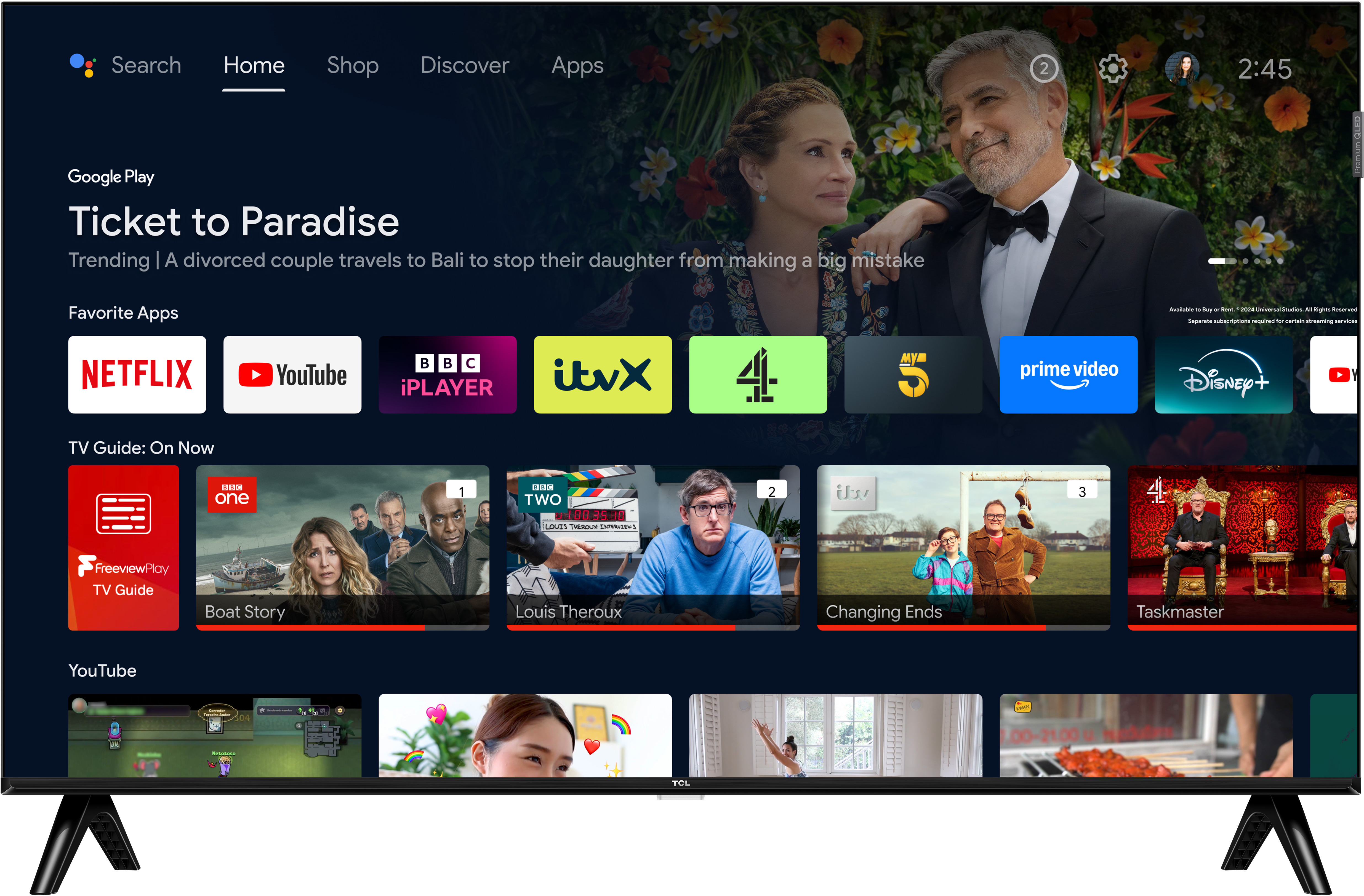 Un téléviseur intelligent affiche une affiche de film, des applications de streaming et des options de guide TV. Des acteurs sont montrés, et le téléviseur a un pied.