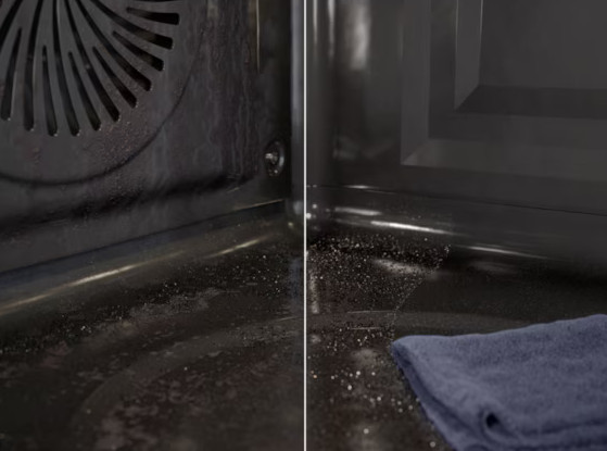 Wnętrze piekarnika pokazuje wentylator, brud i niebieską szmatkę. Piekarnik wydaje się brudny z resztkami. Niebieska szmatka jest po prawej stronie.