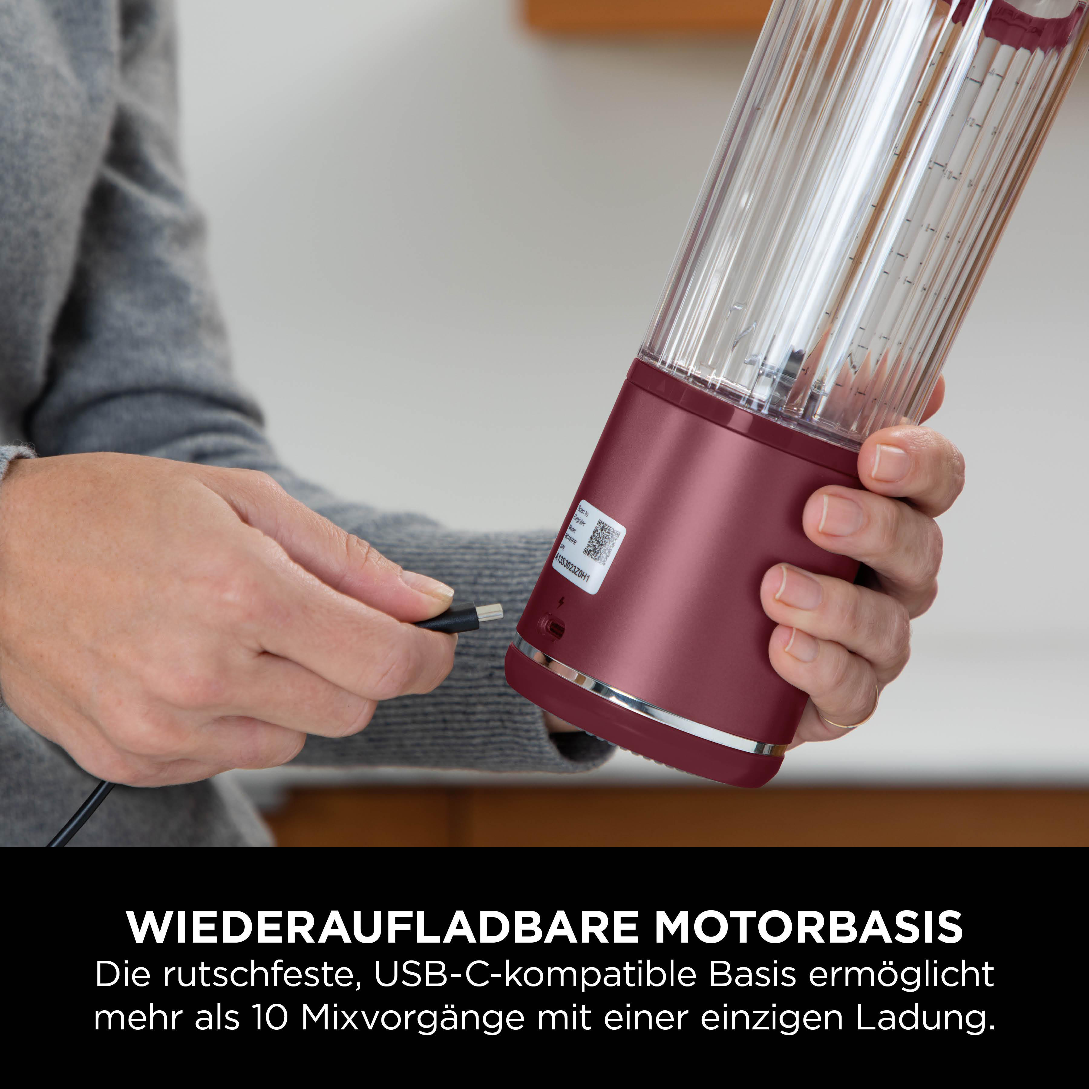 Eine Person, die ein USB-C-Kabel in eine bordeauxrote Blenderbasis einsteckt. Der Mixer hat einen transparenten Behälter.
