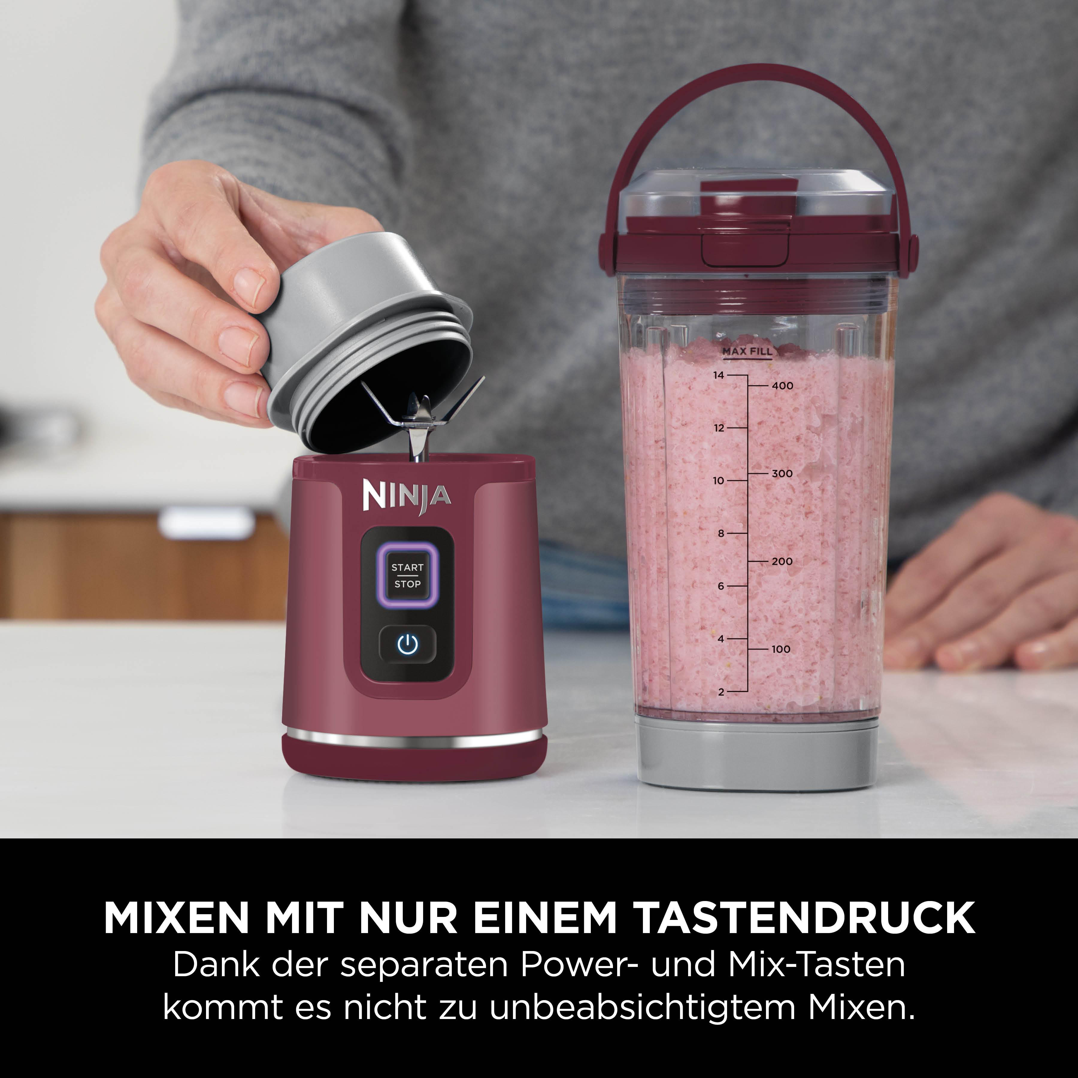 Eine Person gießt einen Mixbecher über einen Ninja-Mixer. Der Becher enthält rosa Flüssigkeit. Der Mixer ist kastanienbraun.