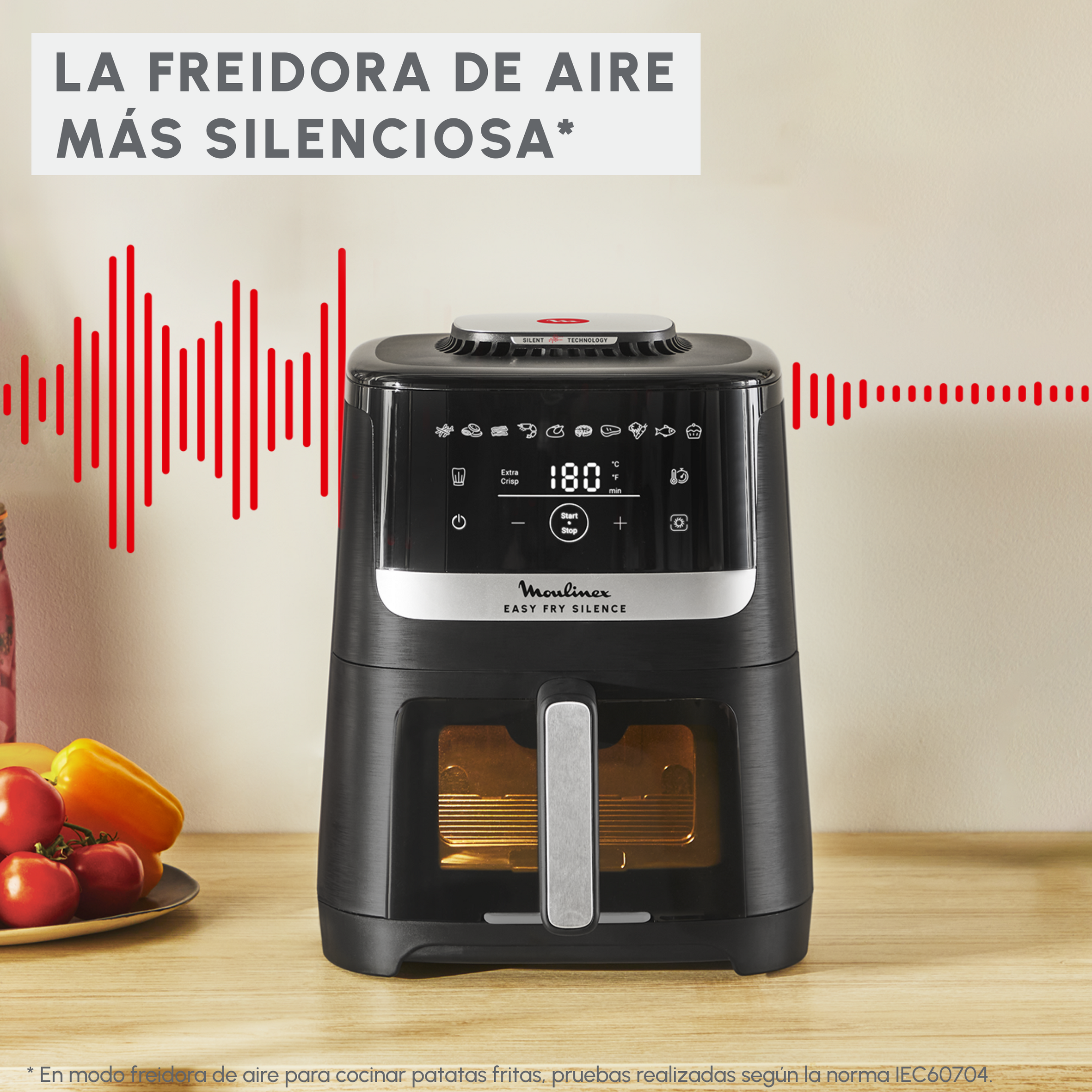 Freidora de aire negra sobre una superficie de madera. Tiene una pantalla digital y la marca 'Moulinex'. Ondas de sonido rojas a la izquierda y derecha.