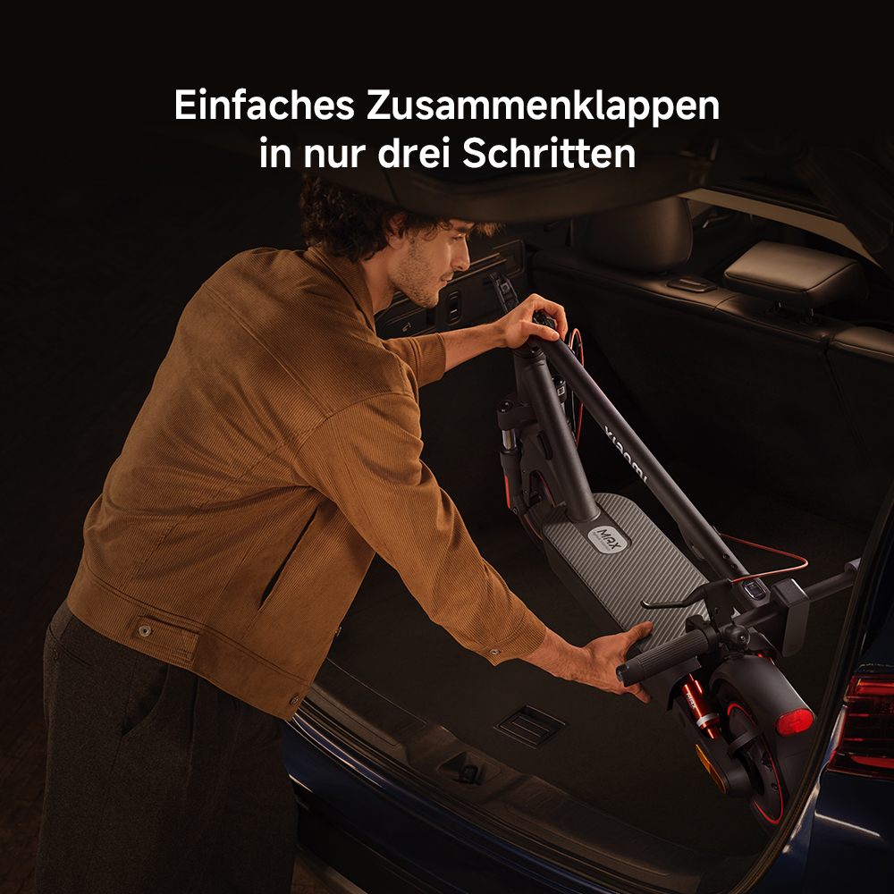 Mann, der einen Elektroroller in einen Kofferraum faltet. Der Roller ist schwarz und grau. Der Mann trägt eine braune Jacke und graue Hose.