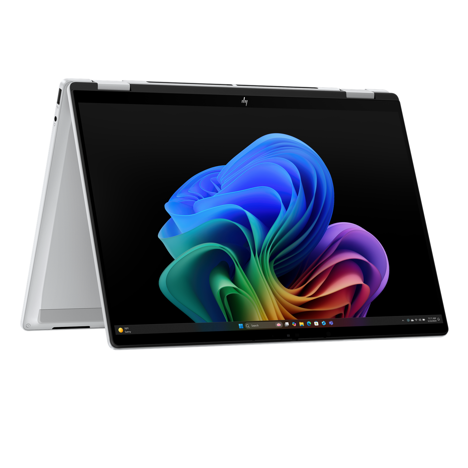 A silver HP laptop is open, displaying a colorful abstract design on its screen. The background is black.