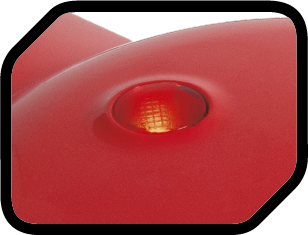 Zbliżenie czerwonej, błyszczącej powierzchni z małym, podświetlonym bursztynowym światłem.