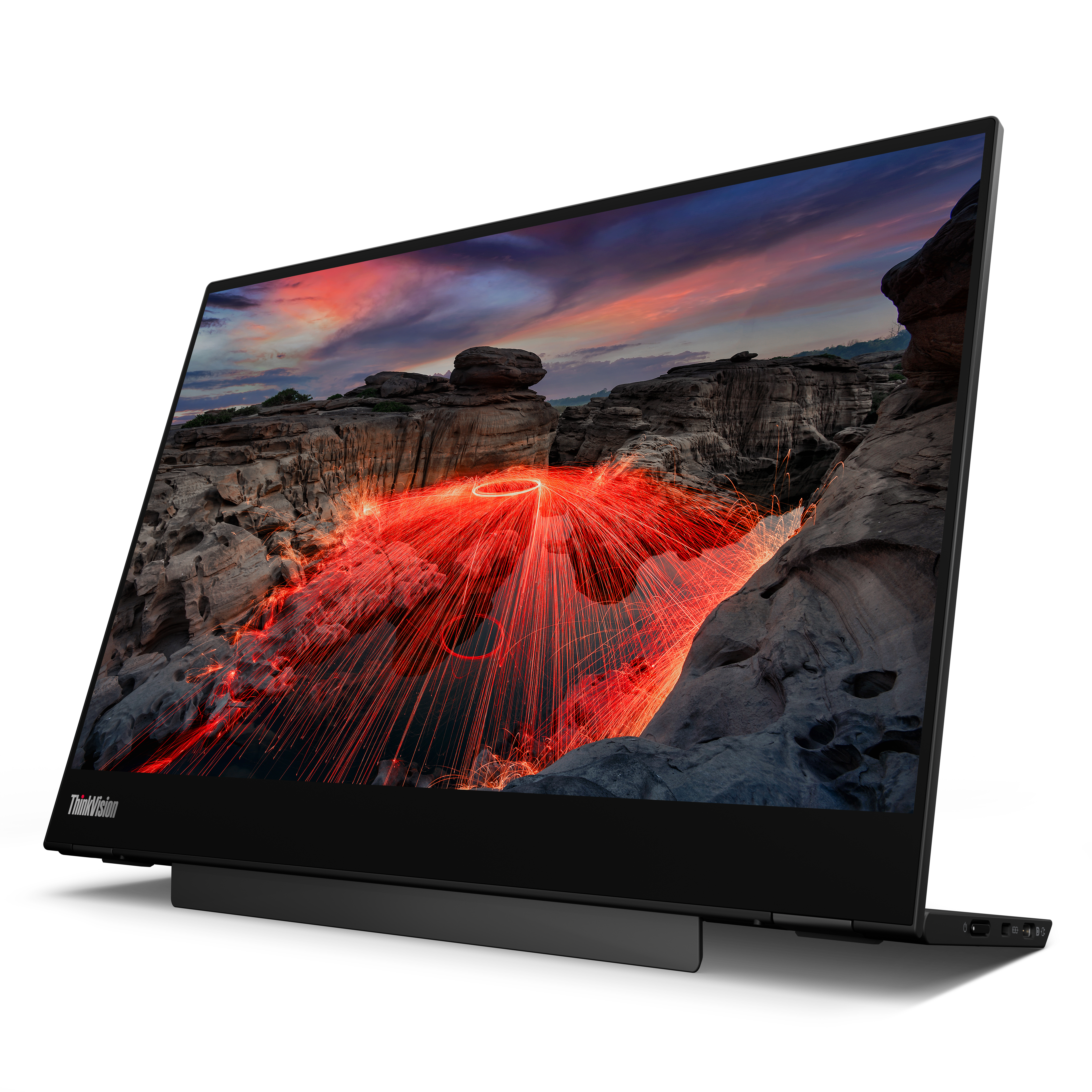 Ein schwarzer ThinkVision-Monitor zeigt eine feurige Szene mit roten Lichtspuren über einer felsigen Landschaft mit Sonnenuntergang.