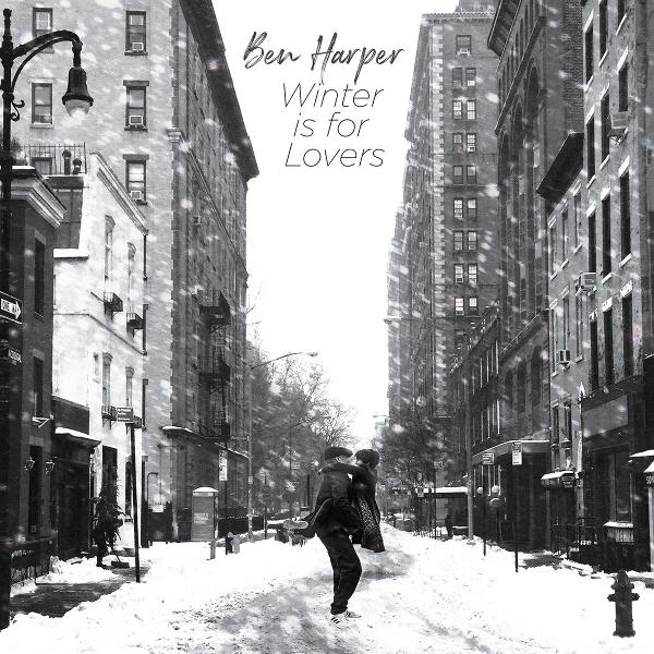 Eine verschneite Straßenszene mit hohen Gebäuden. Ein Paar geht im Schnee. Die Worte "Ben Harper Winter is for Lovers" sind geschrieben.