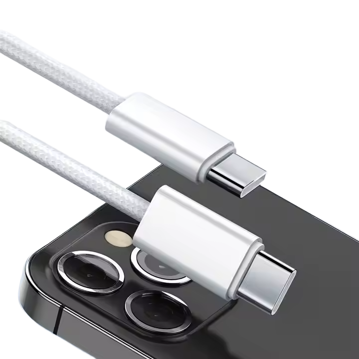Beyaz bir USB-C kablosu bir telefona bağlı. Kablo örgülü. Telefon, arkasında kamera lensleri olan siyah renktedir.