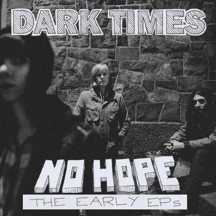 Albumcover. Titel 'Dark Times' oben, 'No Hope' unten. Drei Personen vor einer Steinmauer. Schwarz-Weiß-Foto.