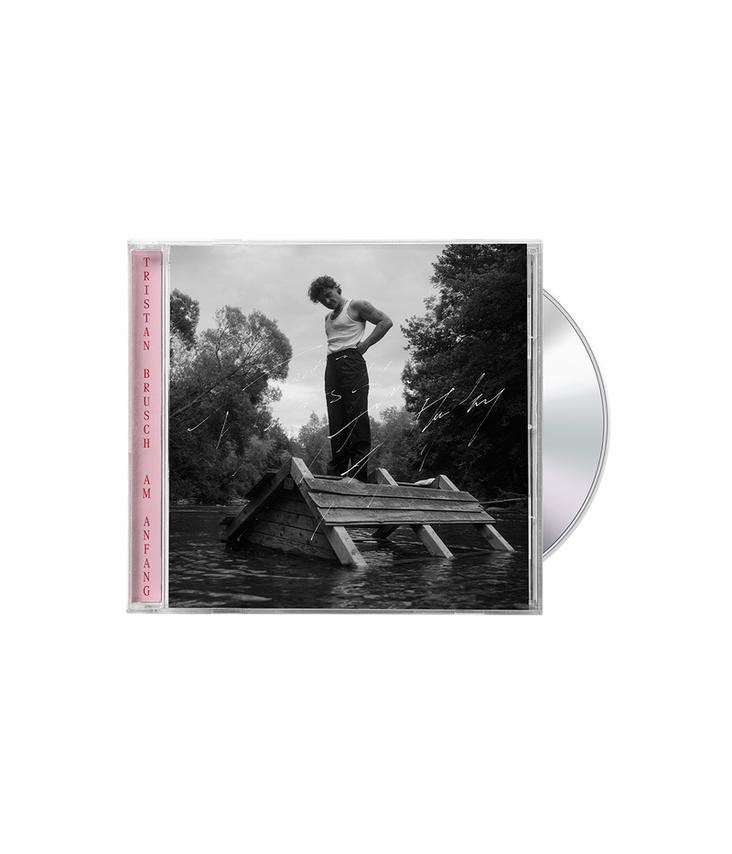 Albumcover. Mann steht auf Holzkonstruktion im Wasser. Bäume im Hintergrund. CD-Hülle mit Text: Tristan Brusch. Am Anfang.