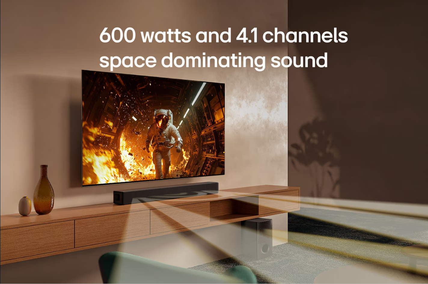 Alevler içindeki astronotlu TV. Ahşap rafta soundbar. Altında bir subwoofer var. Metin: 600 watt ve 4.1 kanal.