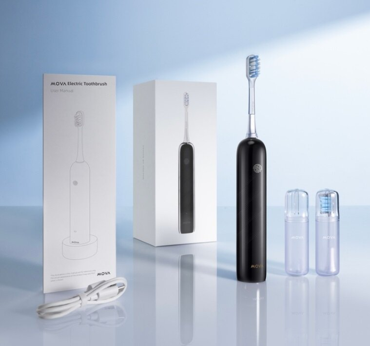 Czarna elektryczna szczoteczka do zębów z dwiema główkami i instrukcją obsługi, wszystko na jasnoniebieskim tle. Obecny jest biały kabel do ładowania.
