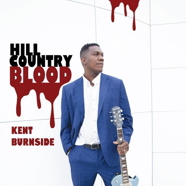 Ein Mann in blauem Anzug hält eine Gitarre. Der Text 'Hill Country Blood' und 'Kent Burnside' sind sichtbar.