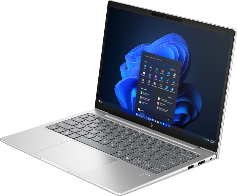 Ein silberner Laptop ist geöffnet und zeigt die Windows 11-Oberfläche. Auf dem Bildschirm werden App-Symbole angezeigt. Die Tastatur ist sichtbar, der Hintergrund ist schwarz.