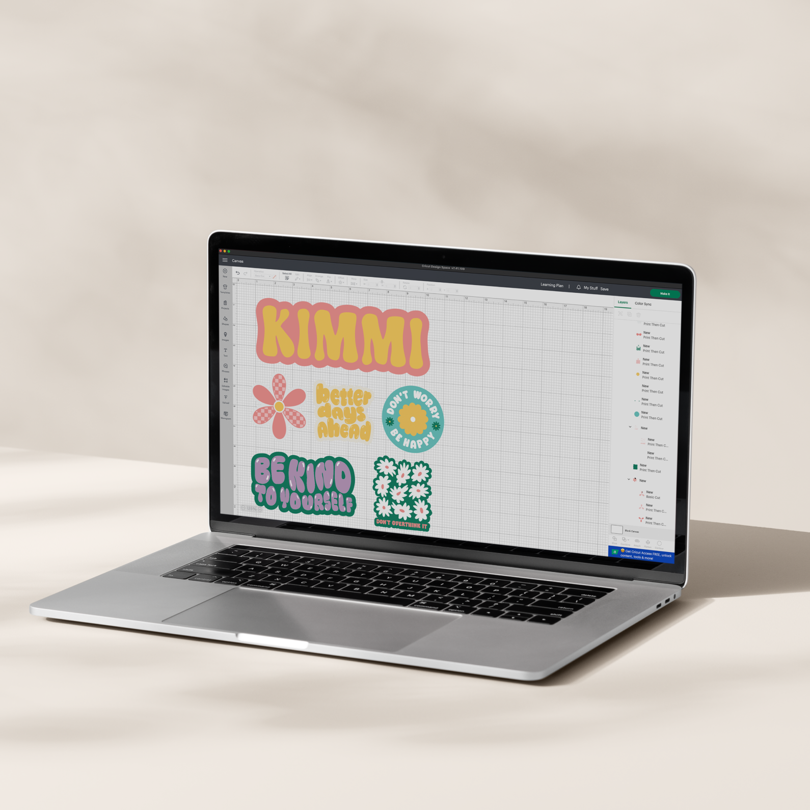 Ein Laptop zeigt Designelemente, darunter Text und florale Grafiken. Der Bildschirm zeigt ein Design mit dem Wort KIMMI und anderen.