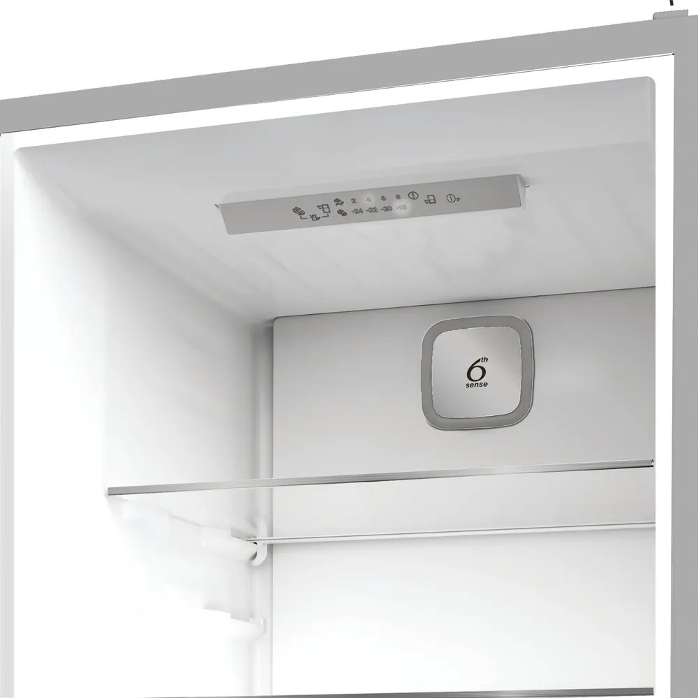 Wnętrze lodówki. Na górze panel sterowania z symbolami. Środek ma logo 6th sense. Szklana półka pośrodku. Białe wnętrze.