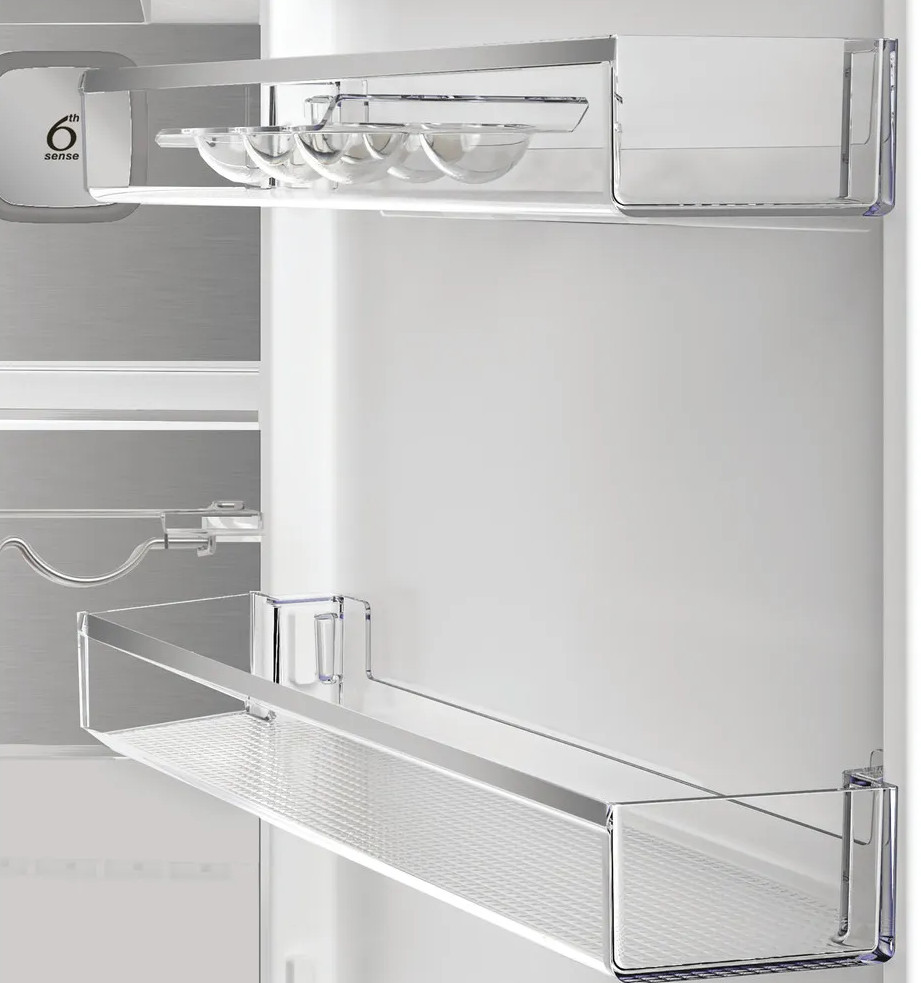 Wewnątrz lodówki widoczne są przezroczyste półki i pojemniki na jajka. Logo '6th sense' znajduje się z boku. Wnętrze jest białe.
