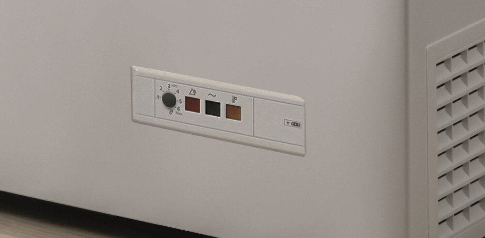 Biała zamrażarka z panelem sterowania pokazującym ustawienia temperatury i symbole. Kratka wentylacyjna po prawej.