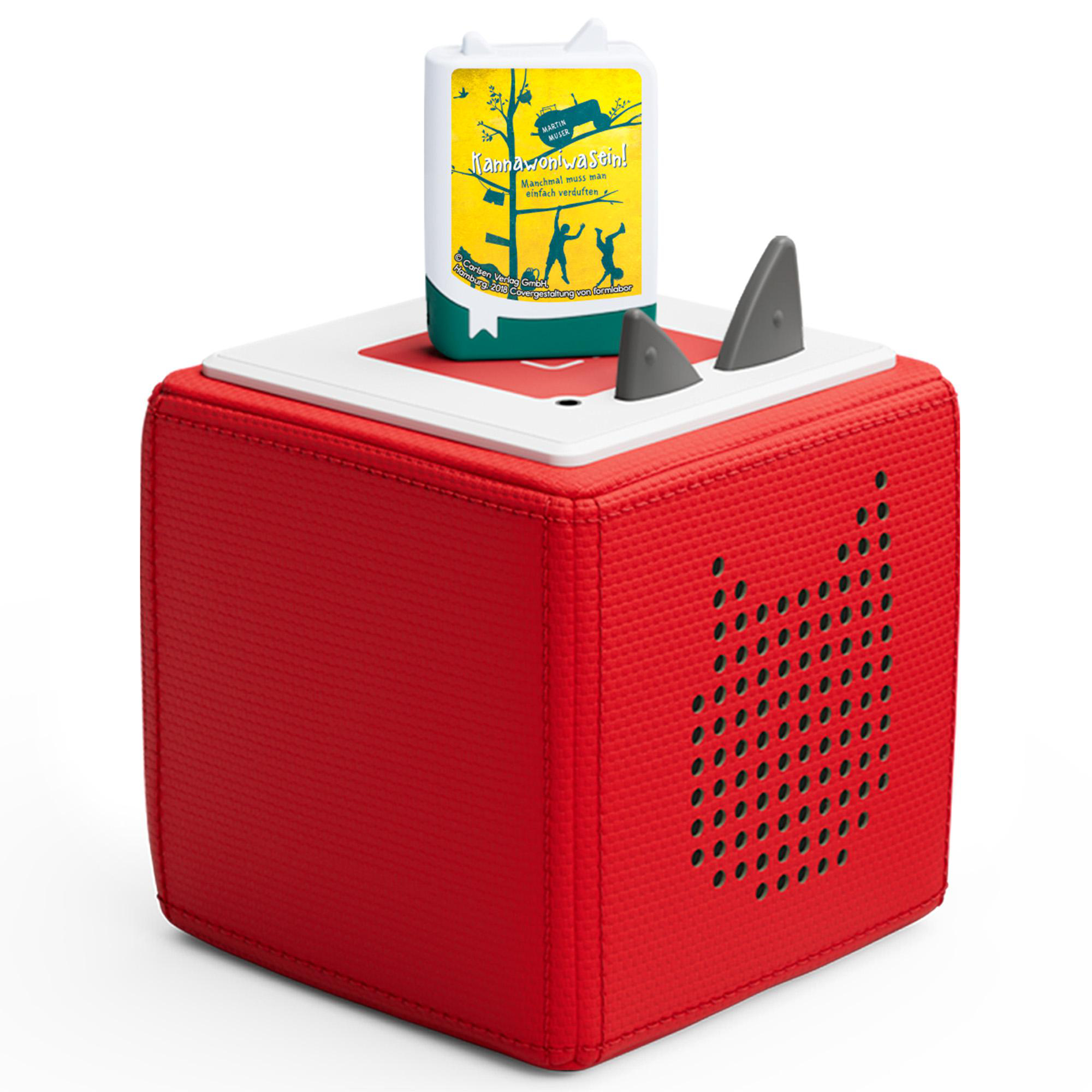 Ein roter, würfelförmiger Lautsprecher mit einem Buch darauf. Das Buch hat einen gelben Einband mit Text und Illustrationen.