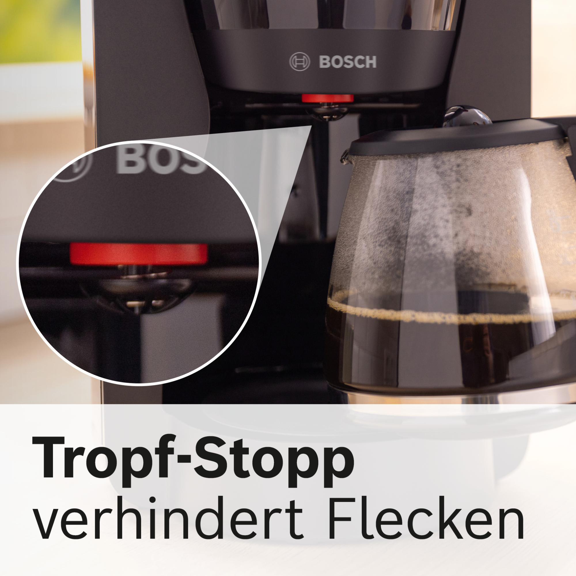 Nahaufnahme einer schwarzen Bosch-Kaffeemaschine. Ein roter Knopf ist sichtbar. Die Karaffe ist voll Kaffee.