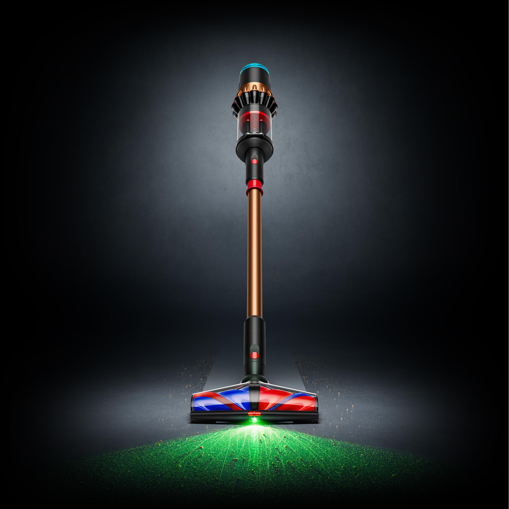 Ein Dyson-Staubsauger wird gezeigt. Er hat einen Kupferstab, einen rot-blauen Bürstenkopf und einen schwarzen Körper. Grünes Licht und Schmutz umgeben ihn.