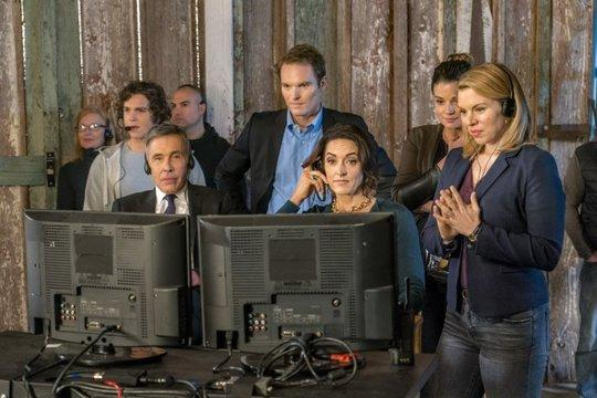 Ein Team von Leuten, die sich hinter Computermonitoren versammeln.
