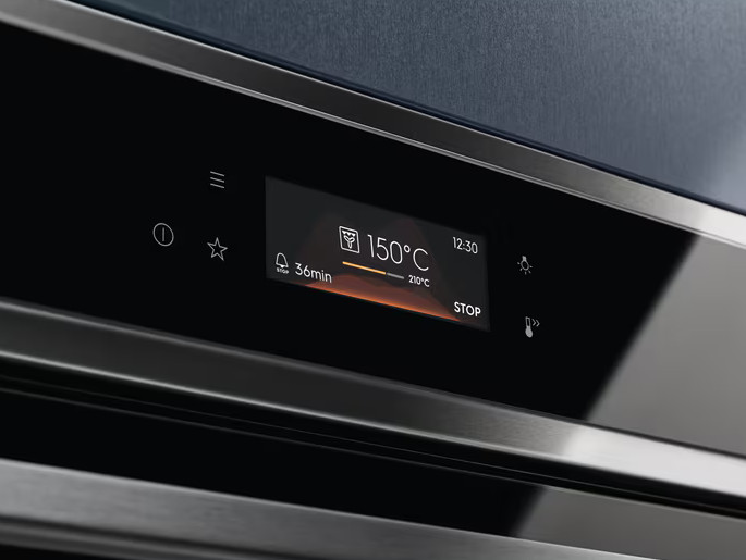 Zbliżenie panelu sterowania piekarnika. Wyświetlacz pokazuje 150°C, 36 min i godzinę. Przyciski: menu, timer i światło.