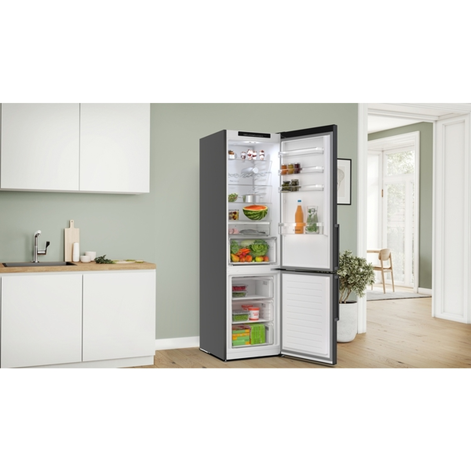 Open koelkast met eten. Keuken met kasten, aanrecht, spoelbak. Achtergrond heeft een deuropening, tafel, stoelen en plant.