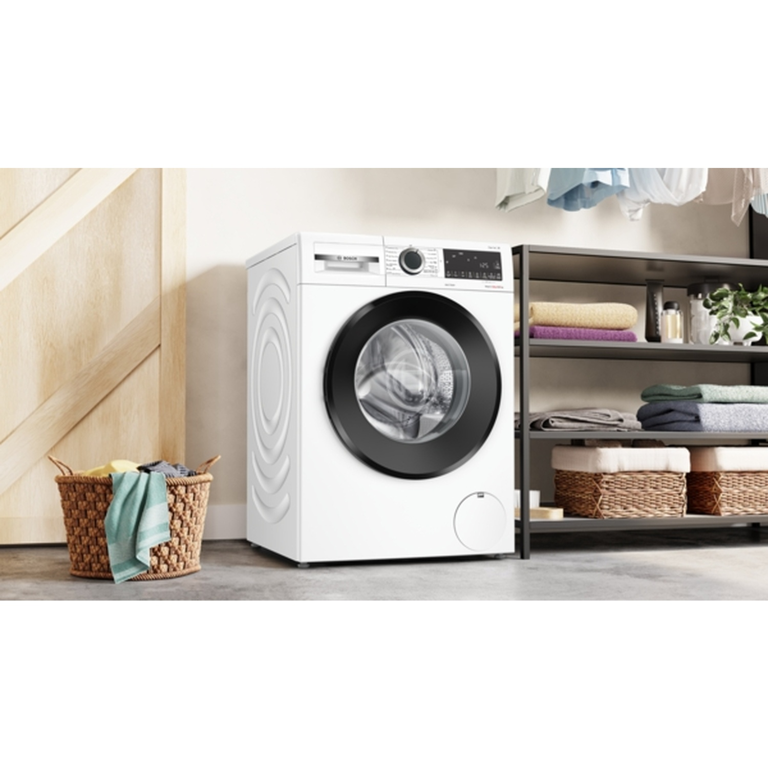 Un lave-linge blanc avec une porte noire, un panier de vêtements et une étagère avec des serviettes et des plantes dans une buanderie.