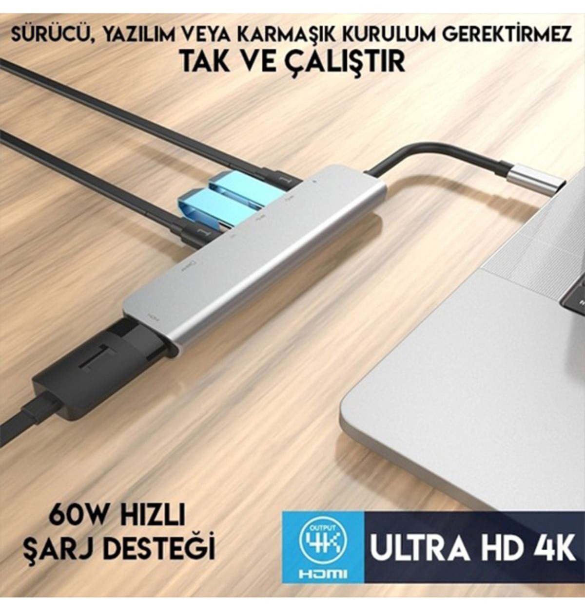 Gümüş bir USB hub, bir dizüstü bilgisayara bağlıdır. Hub'da çoklu bağlantı noktaları var. Metin, hızlı şarj ve Ultra HD 4K'yı gösteriyor.