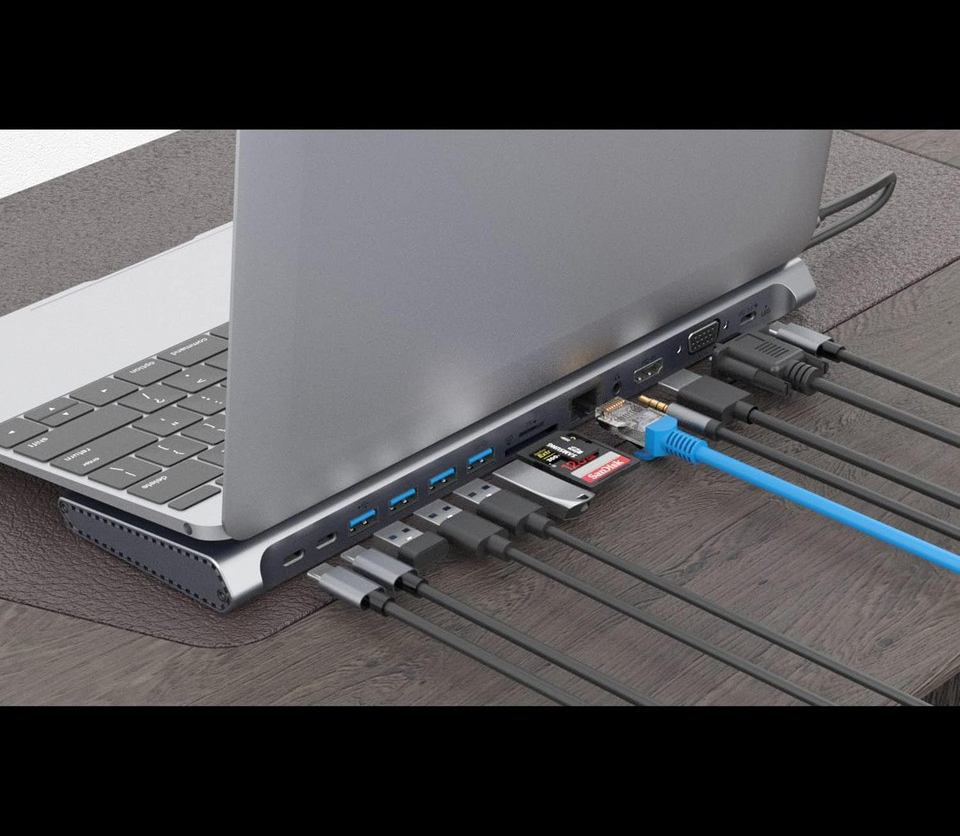 Çeşitli kablolarla bir USB hub'ına bağlı dizüstü bilgisayar. Ahşap bir masada USB, HDMI, Ethernet ve SD kart yuvaları içerir.