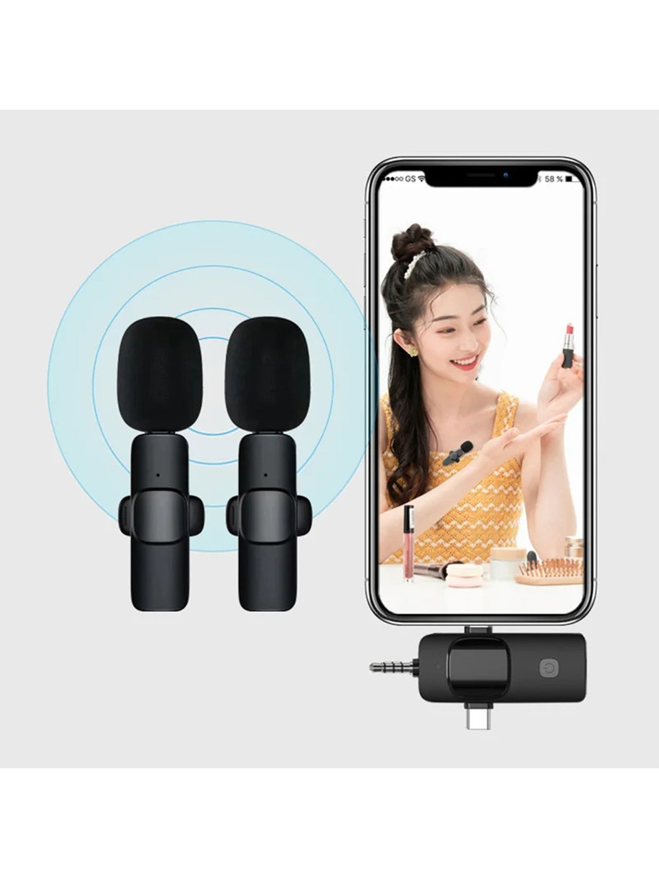 Siyah kablosuz mikrofonlar ve ruj süren bir kadını gösteren bir telefon. Altta küçük bir verici var.
